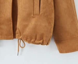 Close-up of yellow suede jacket hem showing drawstring detail and quality side pocket stitching
