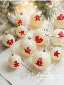 Close-up of cream Christmas ornaments with red star and heart patterns in a festive setting