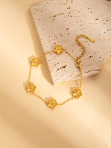Macro detail of 18K gold-plated stainless steel flower bracelet with textured petals