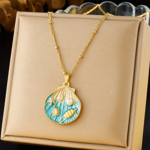 Detail of seashell pendant with blue enamel, starfish relief and pearl on gold chain