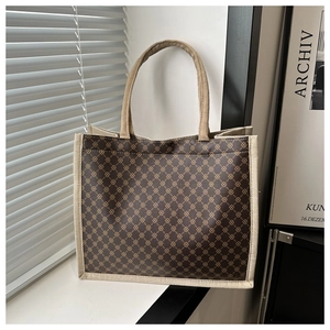 Detail of vintage tote bag featuring geometric chain print and beige linen texture handles