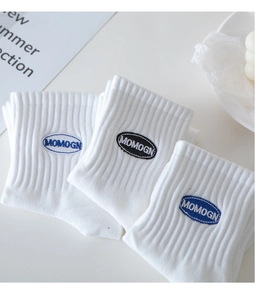 Close-up of white ribbed cotton crew socks with MOMOGN embroidery logo in blue and black