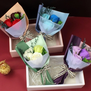 Detail of four colorful soap flower rose bouquets in elegant gift boxes on a red background