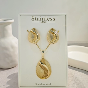 Detail view of water drop wing texture gold stainless steel jewelry set on card