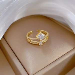 Macro view of gold crown ring with drop-shaped zircon on white silk in a jewelry box