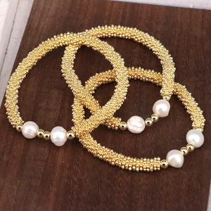 Three-piece handmade bracelet set with golden textured beads and white irregular pearls