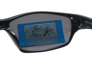 Macro shot of polarized sports sunglasses showing effective light filtration on test card