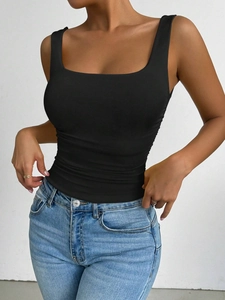 Classic black square-neck tank top paired with light blue denim jeans on a white background