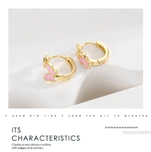 Detailed view of elegant pink butterfly pendant on gold hoop earrings for women