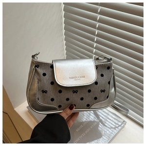 Detail of silver leather shoulder bag with grey polka dots and bow embroidery accents