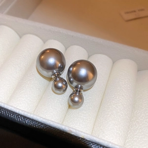 Macro view of gray double pearl earrings set in a beige velvet jewelry gift box
