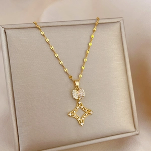 Detail of gold titanium necklace with micro-paved cubic zirconia bow and star pendant