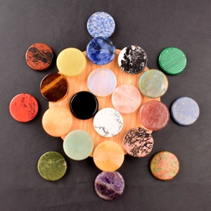 Close-up of assorted 40mm round crystal healing stones on a natural bamboo tray
