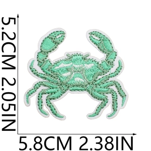 Detail view of a green crab embroidered patch showing 5.8cm width and 5.2cm height dimensions