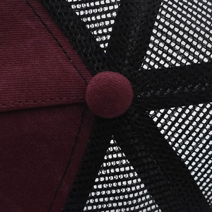Detailed macro view of burgundy cotton fabric and breathable black mesh on baseball cap