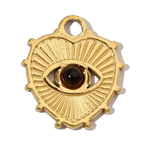 Detail of a golden heart evil eye pendant featuring a black bead and polished finish