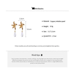 Detailed view of metal flower earrings with drop pearls showing 5.1cm height and 2.1cm width