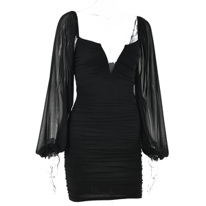 Close-up of black bodycon dress featuring sheer mesh sleeves and ruched V-neck design