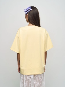 T-shirt graphique oversize jaune pâle à col rond, vue de dos montrée sur un mannequin
