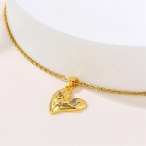 Golden heart necklace with zircon inlay on a minimalist white curved display stand