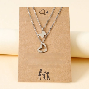 Close-up of mother and daughter butterfly necklaces on brown kraft paper card