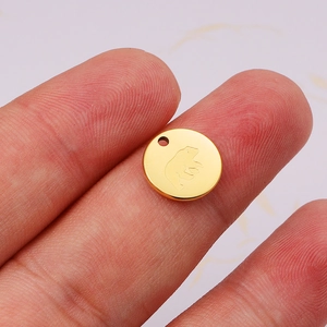 18K gold plated stainless steel round bear pendant charm held between fingers