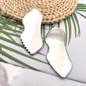 Detailed view of silver stainless steel heart-shaped gua sha tools with serrated edges