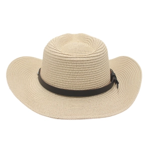 Detailed view of beige straw cowboy hat crown with brown leather band and silver studs