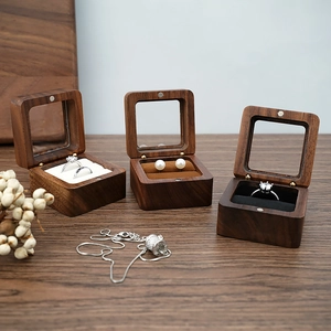 Three walnut wood jewelry boxes with glass lids showing ring and earring compartments