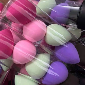 Detailed view of teardrop makeup sponges in pink and purple stored in transparent tube
