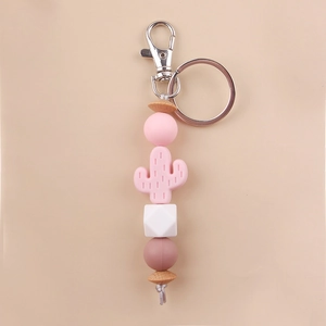 Close-up of pink cactus silicone beads and wooden hexagonal beads on a creative keychain