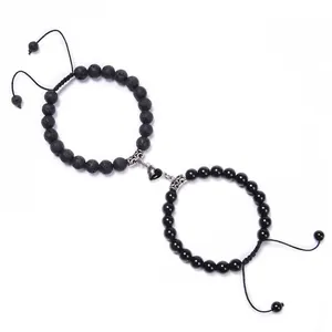 Detail of heart-shaped magnetic clasp on adjustable black beaded couple bracelets