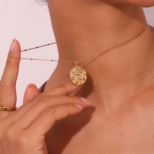 Detail of bohemian gold-plated eye and star moon pendant necklace worn by a model