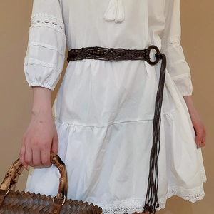 Detail of bohemian braided waist chain with wood beads on white lace dress