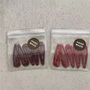 Detail view of 10-piece waterdrop BB hair clip set in dark purple and reddish brown colors