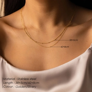Detail of layered stainless steel beaded chain necklace showing adjustable lengths on neck