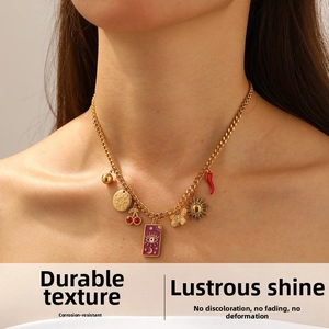 Detailed close-up of a gold Cuban chain necklace with evil eye and cherry charms
