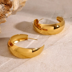 Polished 18k gold plated stainless steel chunky C-shaped hoop earrings on marble surface