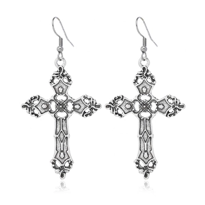 Détail de boucles d'oreilles croix en argent vintage avec textures creuses complexes