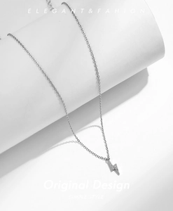 Macro detail of lightning bolt pendant with pavé crystals on a silver chain
