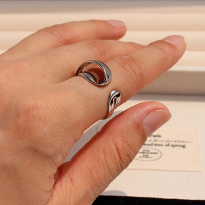 Detailed close-up of a silver irregular double-layer ring on a model hand with soft lighting
