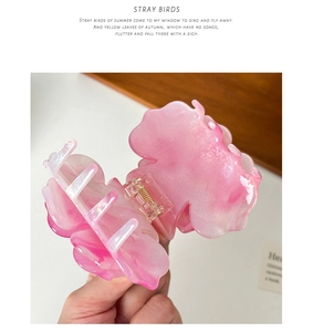 Close-up of pink gradient resin rose hair claw clip with gold metal spring detail