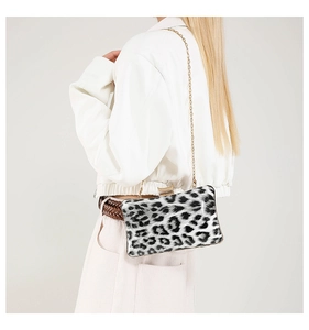 Leopard print square evening bag with gold chain strap shown on a white jacket