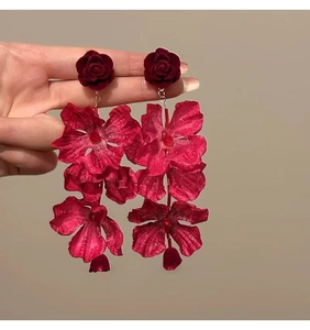Primo piano di orecchini vintage con nappa a fiore rosso e dettaglio in velluto