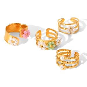 Set of four gold stainless steel open rings with floral and pearl designs on white background