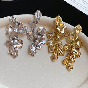 Detailed view of layered metallic flower petal drop earrings in gold and silver finish