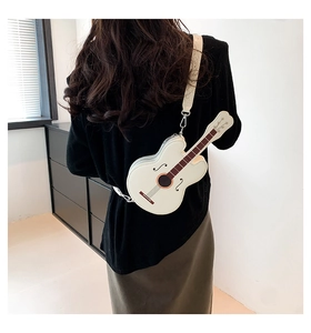 Back view of a white guitar-shaped PU leather crossbody bag worn by a model