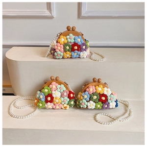 Detailed view of handmade knitted shell bags with floral patterns and pearl straps