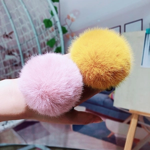 Close-up of pink and yellow plush faux fur hair ties with a soft and fluffy texture