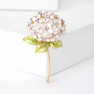 Detail of white enamel hydrangea brooch with pink crystals and golden metal stem
